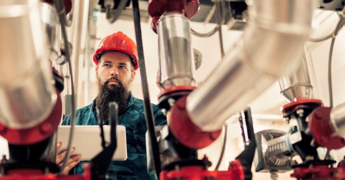 Engenheiro conferindo leitura de sensores em processo industrial.