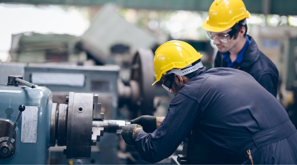 profissionais realizando manutenção preventiva e corretiva em máquina industrial
