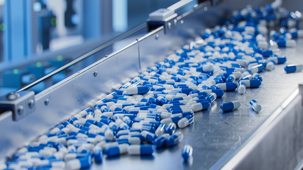 cápsulas de remédio azuis, representando a automação programável na indústria farmacêutica
