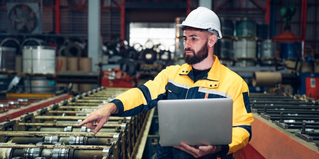 Técnico inspecionando uma máquina na linha de produção para manutenção preditiva