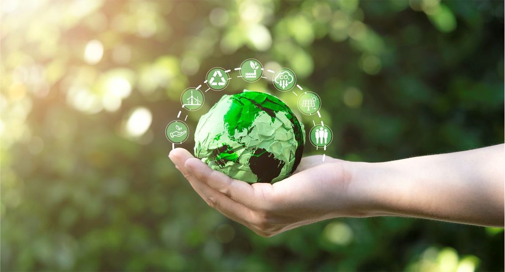 pessoa segurando globo de papel, representando a sustentabilidade industrial