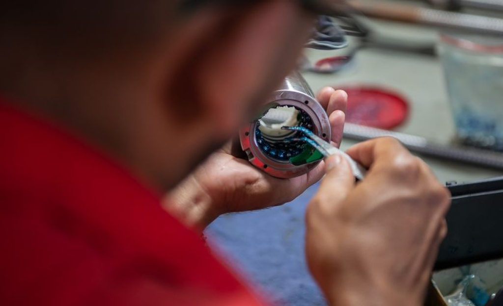 profissional manuseando equipamento representando como montar fuso de esfera​