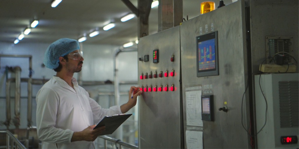 profissional operando controlador em ambiente industrial